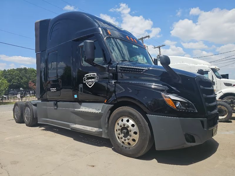 Black Freightliner sleeper cab outside the Dallas shop